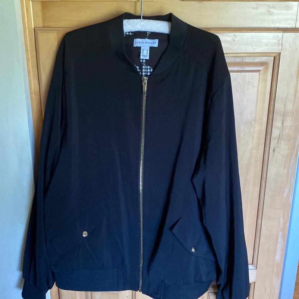 Black jacket, reversible if desired, with gold zipper and pocket embellishments.